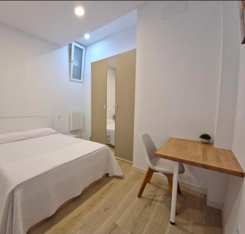 a bedroom with a bed and a desk and a table at Moderno Estudio en Alcobendas in Alcobendas