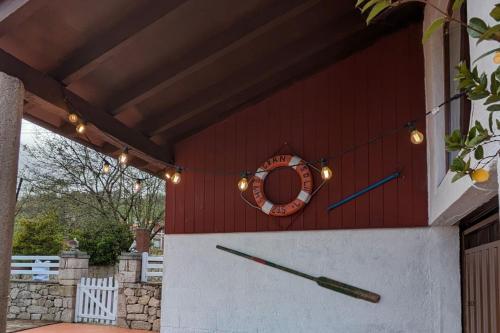 a red building with a clock on the side of it at Casa de campo La Casuca Del Monje, San Vicente de la Barquera in La Acebosa
