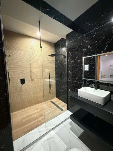 a bathroom with a glass shower and a sink at The View Hotel CV in São Filipe