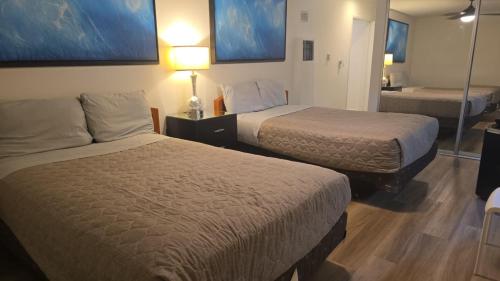 a hotel room with two beds and a mirror at West LA Boutique Apartments Minutes from the Coast in Los Angeles