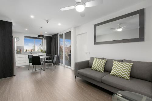 
a living room filled with furniture and a large window at Menso at Southbank in Brisbane
