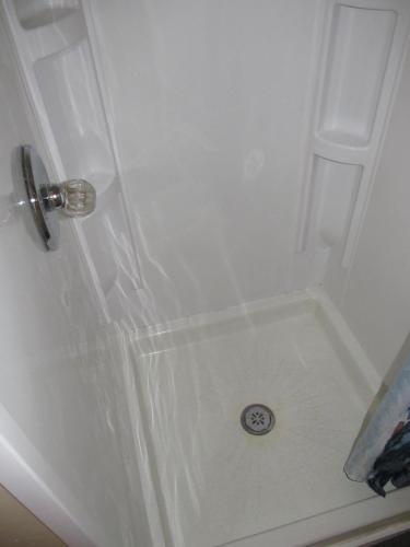a shower with a white door with a drain at Cozy Vintage Chicago Apartment near Downtown in Chicago