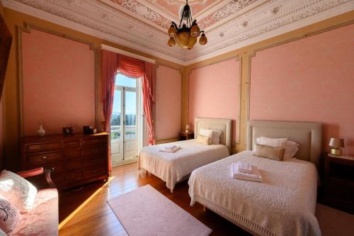 a bedroom with two beds and a window at Outeiro-Quinta de São Francisco in Viana do Castelo