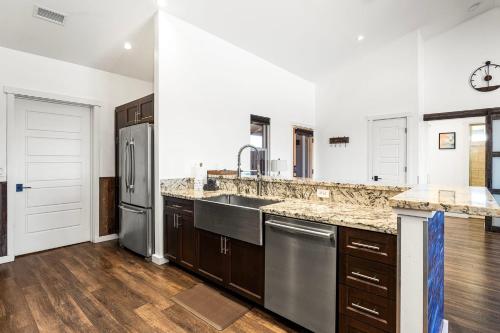a kitchen with stainless steel appliances and wooden floors at Ainamalu 9 in Waikoloa
