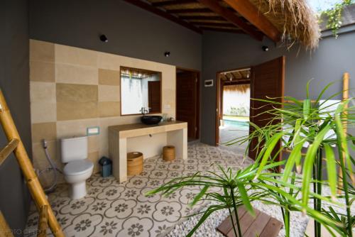 a bathroom with a toilet and a sink at Villa Saia in Gili Air