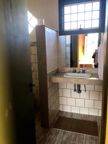 a bathroom with a sink and a mirror at Pousada Condado Santa Maria in Baependi