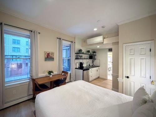 a bedroom with a bed and a table and a kitchen at Copley House in Boston