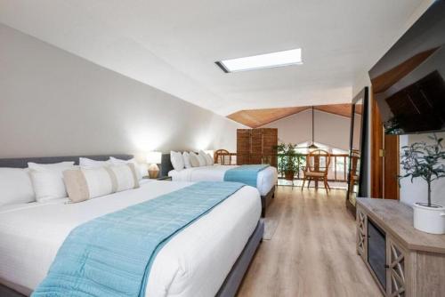a hotel room with two beds and a television at Forest Home with Deck, EV Station, King Beds in Cambria