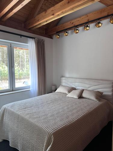 a bedroom with a large white bed with a window at Dom pod Aniołem in Sierakowice Prawe