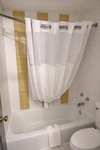 a bathroom with a white tub and a toilet at Days Inn by Wyndham Amherst OH - Near Cleveland Cedar Point & Lake Erie in Amherst