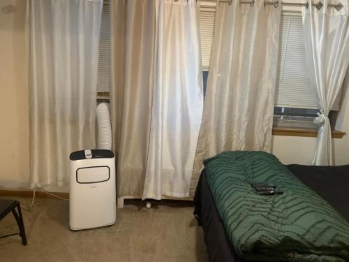 a bedroom with a bed and a window with curtains at The Upper Room in Milwaukee