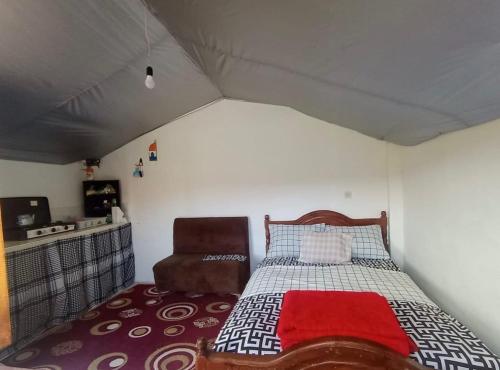 ein Schlafzimmer mit einem Bett und einem Stuhl in einem Zimmer in der Unterkunft LuxeCabane in Kouf el Fouki