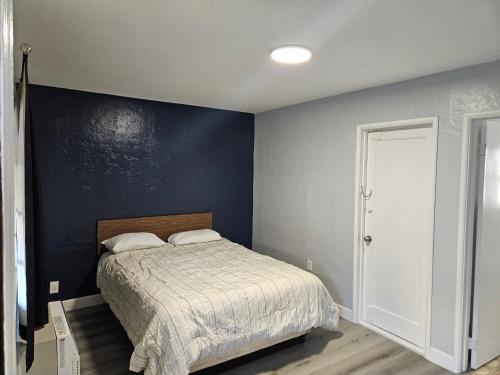 a bedroom with a bed and a blue wall at Nights Inn Motel in Oakland