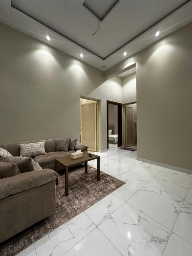 a living room with a couch and a table at شقق وغرف الرصف in Hail