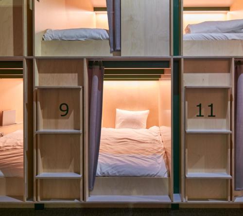 a group of bunk beds in a room with a bed at Green Marmot Capsule Hotel Genève - Self check-in in Geneva