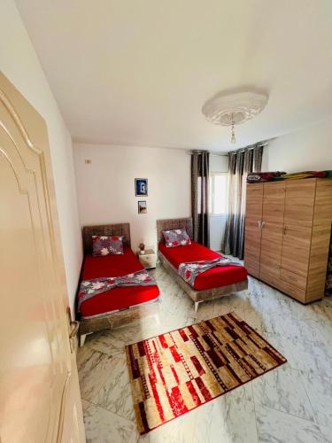 a living room with two beds and a rug at Villa Joury in Al Maqārisah