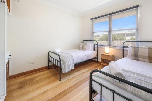 a bedroom with two bunk beds and a window at Jack & Bias Cottage in Warrnambool
