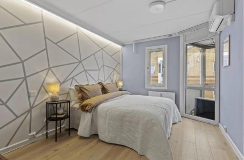 a bedroom with a bed and a wall at Elegant apartment in Oslo