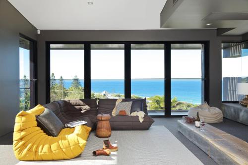 a living room with a couch and a large window at Thirteen Bowman - Sunshine Beach, Ocean Views in Sunshine Beach