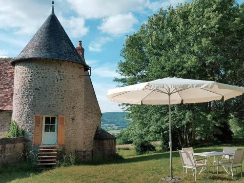 a table with an umbrella in front of a building at Cosy Castle with Pool in Onlay in Onlay