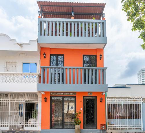 an orange building with a balcony on top at Casa Presentacion Adaz Hotel in Santa Marta
