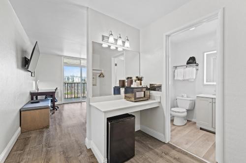 a white bathroom with a sink and a toilet at Marina Village Inn in Alameda