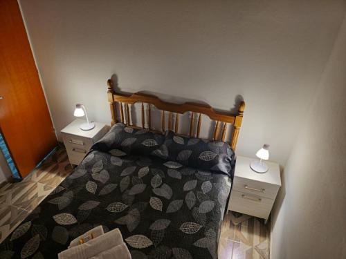 a bedroom with a bed with two nightstands and two lamps at Departamentos Los Árboles in San Francisco del Monte de Oro