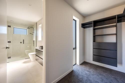 a bathroom with a toilet and a walk in shower at Carrickmore Lodge in Wanaka