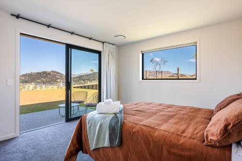 a bedroom with a bed and a view of the desert at Carrickmore Lodge in Wanaka