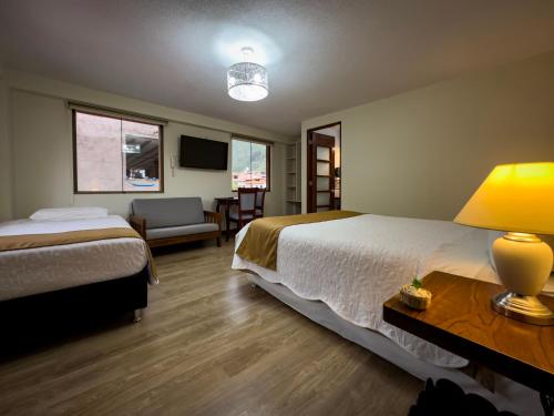 a hotel room with two beds and a table with a lamp at La Posada de Francisca in Pisac