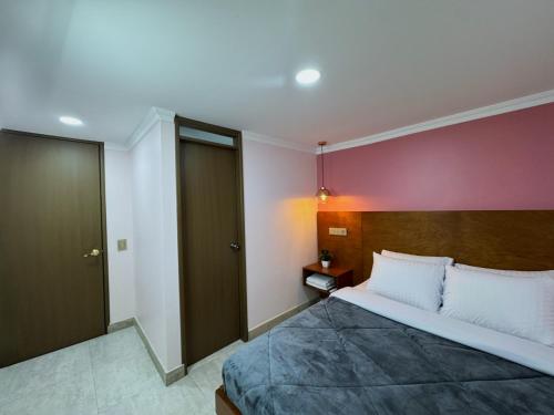a bedroom with a large bed and a red wall at KLEINN HOTEL BOGOTÁ in Bogotá