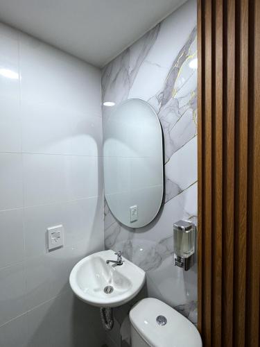 a bathroom with a sink and a toilet and a mirror at KLEINN HOTEL BOGOTÁ in Bogotá