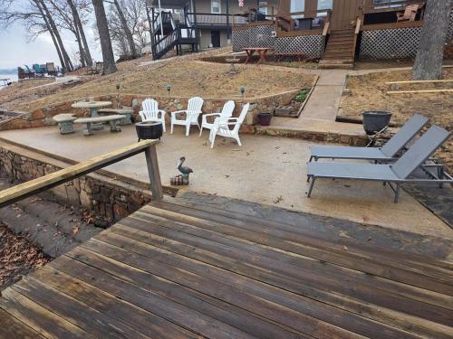 a group of chairs and a table and a bench at Shady Valley Lakefront Cottage in Sunrise Beach