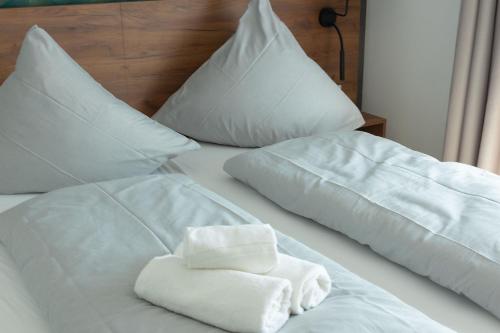 ein Bett mit weißen Handtüchern und Kissen darauf in der Unterkunft Küstenbrise in Carolinensiel