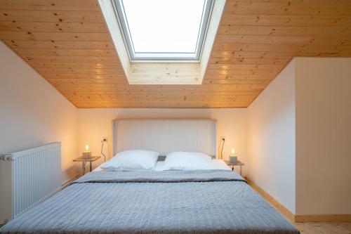 a bedroom with a large bed with a skylight at Hof Friesenruhe in Högel