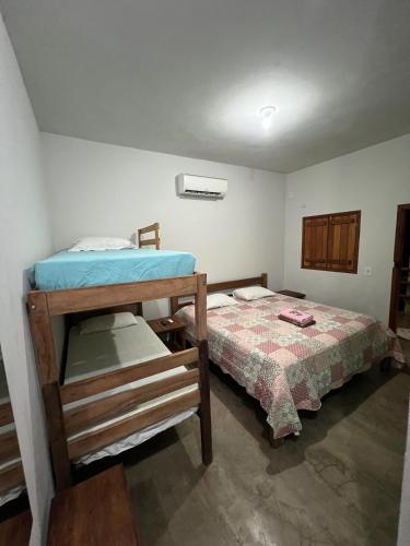 a bedroom with a bunk bed and a bed at Quintal De Minas in Delfinópolis