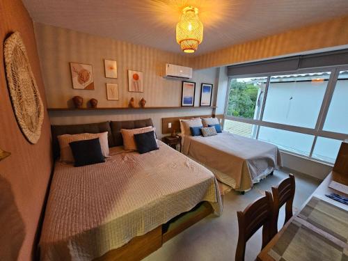 a bedroom with two beds and a window at Contemporâneo Absolute e piscina com borda infinita in Morro de São Paulo