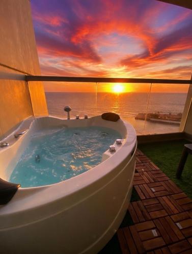a bath tub with a sunset in the background at برج داماك الكورنيش - Damac Al-Corniche Tower in Jeddah