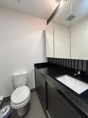 a bathroom with a white toilet and a sink at Loft Exclusivo - Maxplaza in Canoas