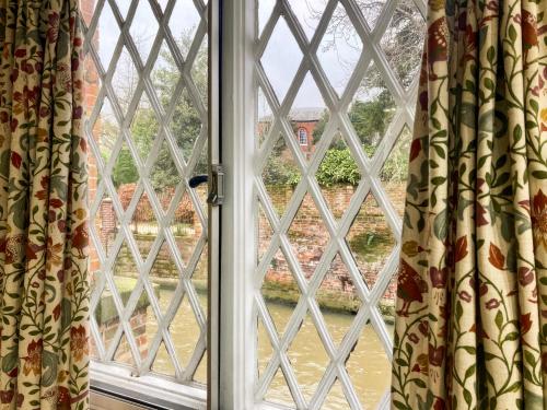 an open window with a view of a yard at The Yeomans Cottage, Eastbridge Hospital in Canterbury