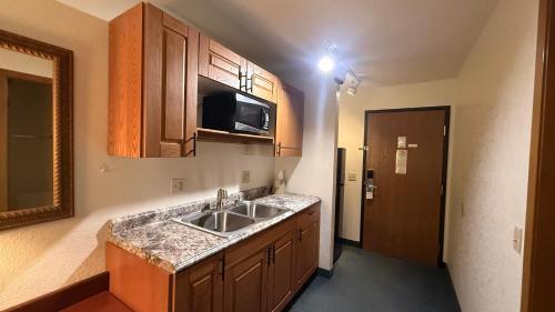 a kitchen with a sink and a microwave at clarion hometown inn in Clarion
