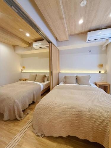 two beds in a room with two beds sidx sidx sidx sidx at Ueno K in Tokyo