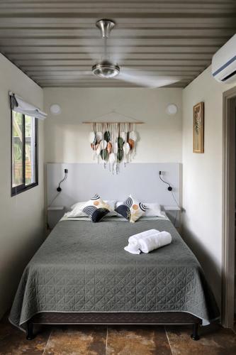 a bedroom with a large bed with a gray comforter at Green Sanctuary Hotel in Nosara