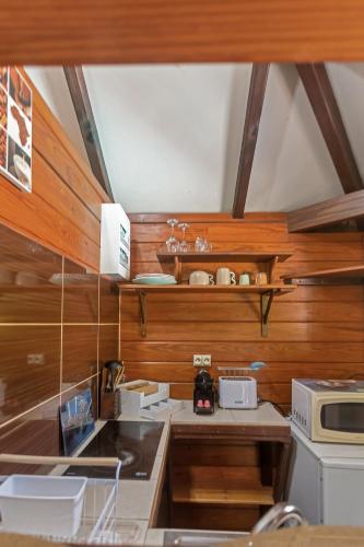 a kitchen with wood paneling and a counter top at Les Cottages Couleur Café in Cul de Sac