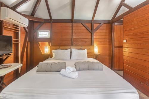a bedroom with a large bed with two towels at Les Cottages Couleur Café in Cul de Sac