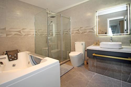a bathroom with a tub and a sink and a toilet at Your Private Escape with city views in Auckland