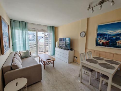 a living room with a couch and a table at Seafront apartment S'Abanell Central Park with pool in Blanes