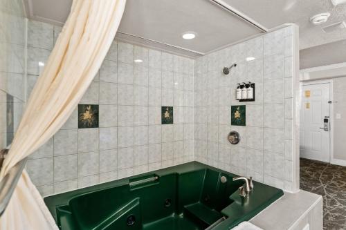 a bathroom with a green tub and a sink at Rose Garden Inn - San Jose Airport in San Jose