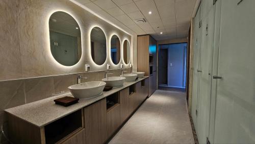 a bathroom with four sinks and a row of mirrors at OstelloMaree 오스텔로마레 Tax Benefit in Seoul