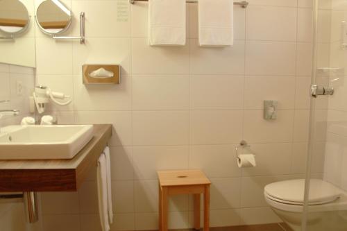 a white bathroom with a sink and a toilet at Chalet-Gafri - BnB - Frühstückspension - Service fast wie im Hotel in Wilderswil